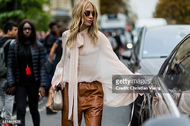 Elena Perminova wearing a white blouse and brown leather pants outside Chloe on September 29, 2016 in Paris, France.