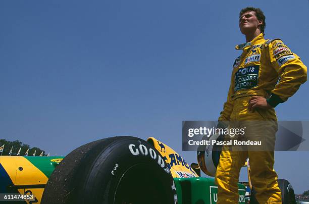 Michael Schumacher of Germany stands beside his Camel Benetton Ford Benetton B192 Ford HB V8 after retiring from the San Marino Grand Prix with...