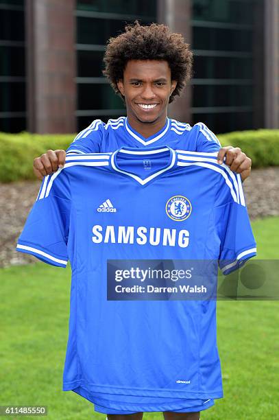 Chelsea's Willian in the Chelsea kit holding the home shirt at the Cobham Training Ground on 28th August 2013 in Cobham, England.