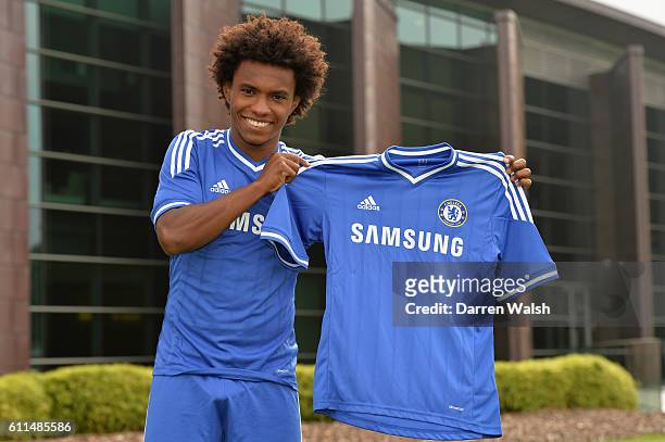 Chelsea's Willian in the Chelsea kit holding the home shirt at the Cobham Training Ground on 28th August 2013 in Cobham, England.