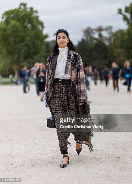 Caroline Issa wearing a plaid poncho outside Carven on September 29, 2016 in Paris, France.