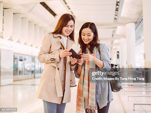 two ladies looking at passport at train station - plane ticket stock pictures, royalty-free photos & images