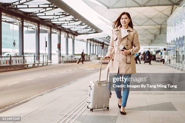 young lady with luggage strolling at airport - airport terminal interior stock pictures, royalty-free photos & images