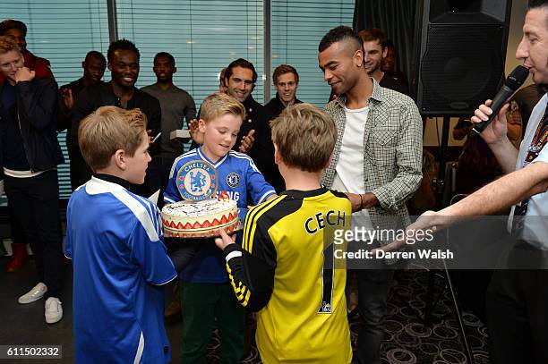 Ashley Cole is presented with a Birthday cake by young fans during a children's Christmas party at Stamford Bridge