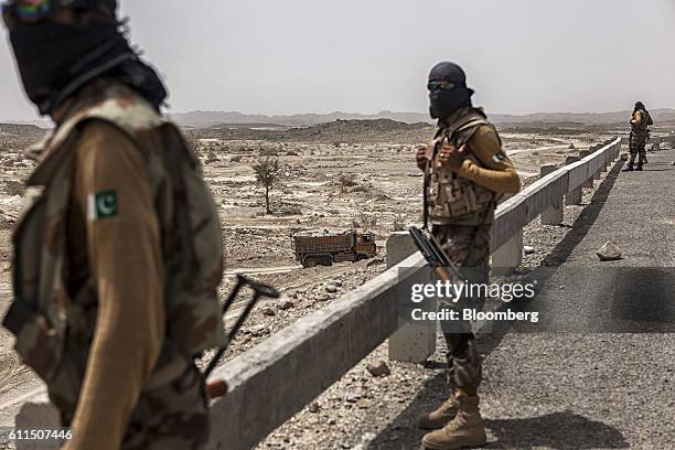 Members of the security forces observe operations at a site where workers gather materials for the construction of the M8 motorway on the outskirts...