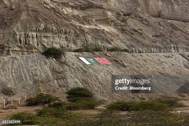 The national flags of Pakistan, left, and China are displayed on the side of a mountain in Gwadar, Balochistan, Pakistan, on Wednesday, Aug. 3, 2016....