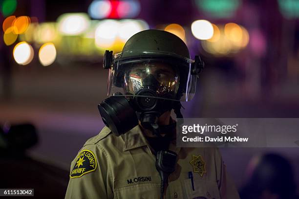 San Diego County Sheriffs deputy wear a gas mask as an unlawful assembly is declared near the site where an unarmed black man, Alfred Olango was shot...