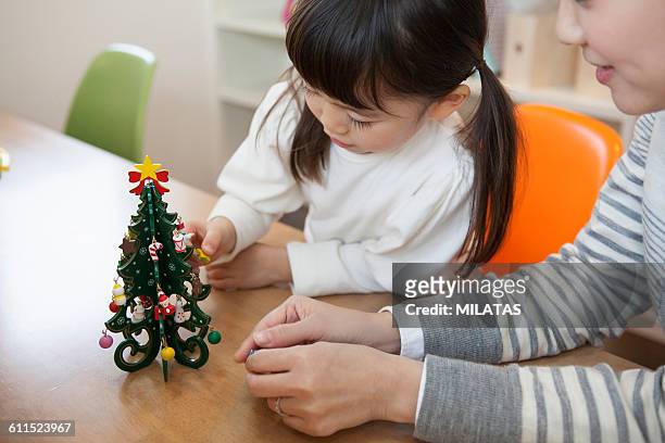japanese girl to decorate the christmas tree - homeowners decorate their houses for christmas stockfoto's en -beelden