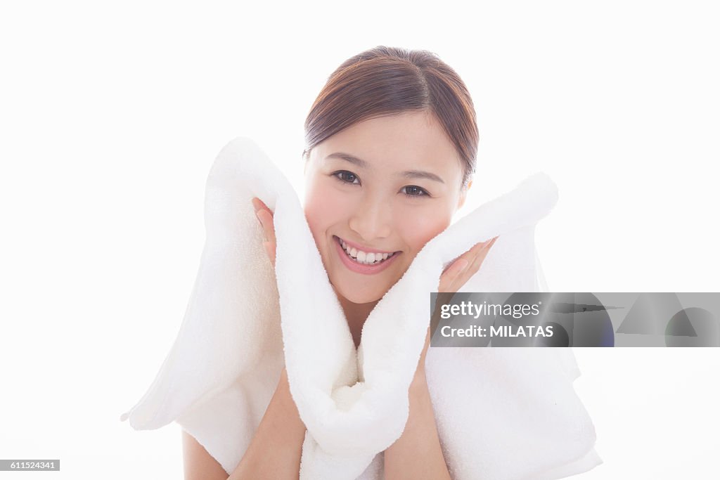 Japanese woman wiping the face with a towel