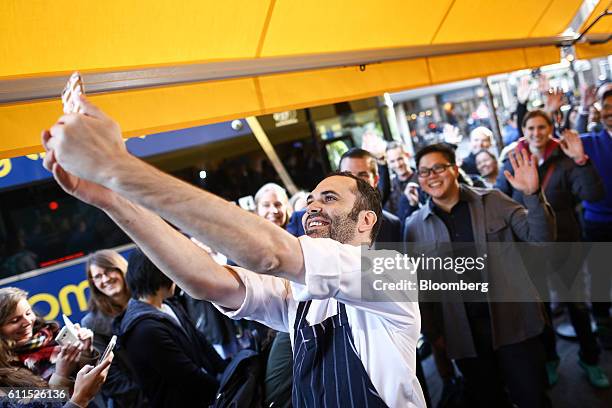 Dominique Ansel, chef and owner at Dominique Ansel Bakery takes a selfie photograph with customers who are queuing to enter the Dominique Ansel...