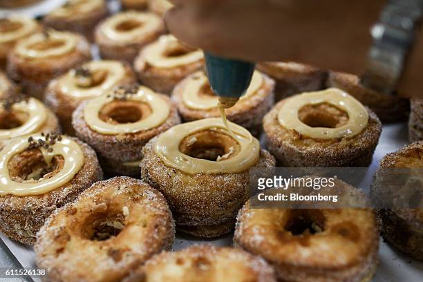 Bakers pipe icing onto Cronuts ahead of the opening of the Dominique Ansel Bakery in London, U.K., on Friday, Sept. 30, 2016. The Cronutthe...