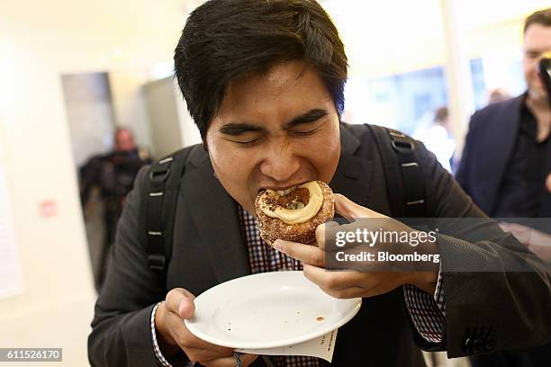 Customer bites into his Cronut during the opening of the Dominique Ansel Bakery in London, U.K., on Friday, Sept. 30, 2016. The Cronutthe...