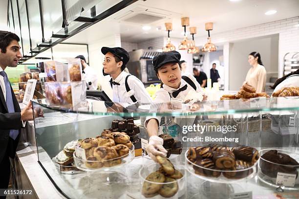 Employees serve customers during the opening of the Dominique Ansel Bakery in London, U.K., on Friday, Sept. 30, 2016. The Dominique Ansel Bakery, is...