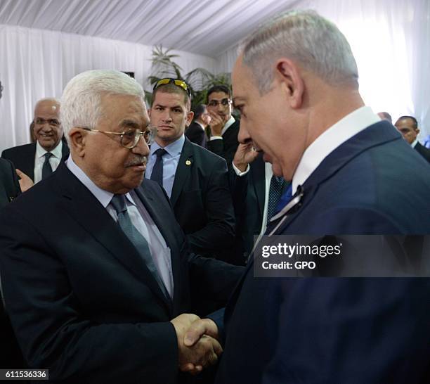 In this handout photo provided by the Israel Government Press Office , Israeli Prime Minister Benjamin Netanyahu shakes hands with Palestinian...