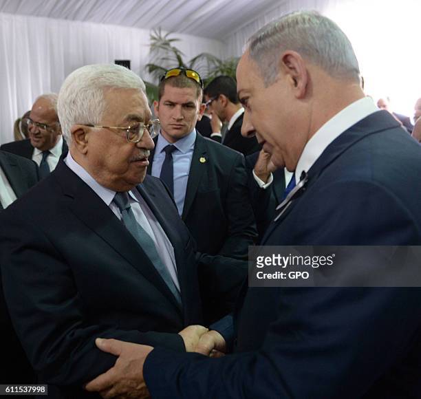 In this handout photo provided by the Israel Government Press Office , Israeli Prime Minister Benjamin Netanyahu shakes hands with Palestinian...