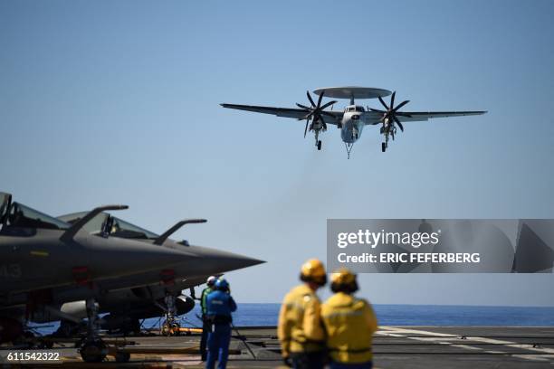 Hawkeye surveillance aircraft approaches before landing on the deck of French aircraft carrier Charles de Gaulle, in the Mediterranean Sea on...