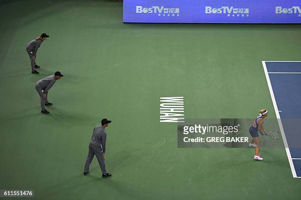 Linesmen look on as Dominika Cibulkova of Slovakia prepares to receive serve during her semi-final match against Svetlana Kuznetsova of Russia at the...