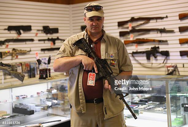 Shop owner Jeff Binkley displays an AR-15 "Sport" rifle at Sarge's Sidearms on September 29, 2016 near Benson, Arizona. He said he redesigned and...