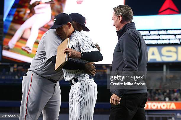 Jacoby Ellsbury of the New York Yankees and David Cone presents a gift to David Ortiz of the Boston Red Sox during a pregame ceremony at Yankee...