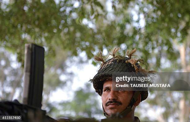 An Indian army soldier keeps vigil at an outpost near the India-Pakistan border in Abdullian, southwest of Jammu on September 30, 2016. India...