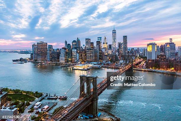 aerial of new york city and brooklyn bridge at dusk - puente de brooklyn fotografías e imágenes de stock