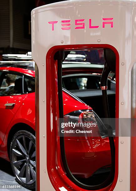 Tesla electric charger is displayed next to a Telsa model S car during the second press day of the Paris Motor Show on September 30 in Paris, France....