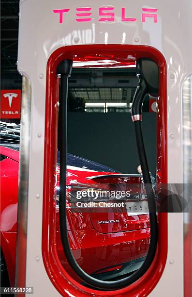 Tesla electric charger is displayed next to a Telsa model S car during the second press day of the Paris Motor Show on September 30 in Paris, France....