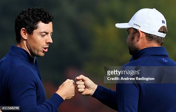 Rory McIlroy and Andy Sullivan of Europe react on the 12th green during morning foursome matches of the 2016 Ryder Cup at Hazeltine National Golf...