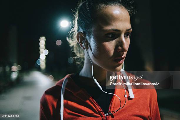 portrait of young fitness woman in park at night - extra portraits stockfoto's en -beelden