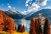 Autumn view with red foliage of Alps with lake