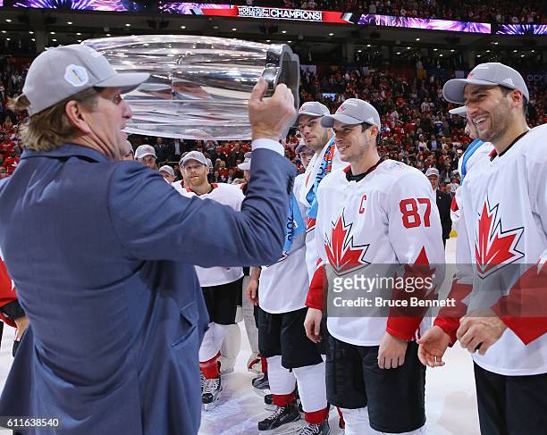 Head coach Mike Babcock hands the World Cup of Hockey to Team Canada players following the Game Two victory against Team Europe in the World Cup of...