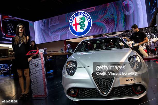 Model poses next the new Alfa Romeo MiTo during the press preview of the Paris Motor Show at Paris Expo Porte de Versailles on September 30, 2016 in...