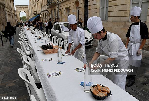 Helpers prepare the tables for the wine harvesting festival "La rue gourmande" in Bordeaux, southwestern France, on September 30, 2016. The festival...