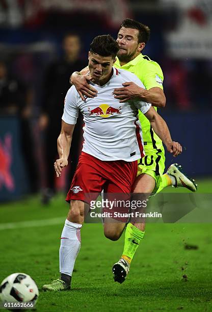 Marcel Sabitzer of Leipzig is challenged by Daniel Baier of Augsburg during the Bundesliga match between RB Leipzig and FC Augsburg at Red Bull Arena...