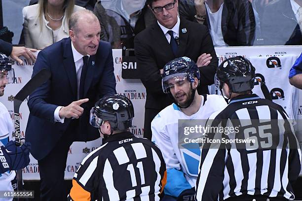Team Europe head coach Ralph Krueger debates a penalty call with referee Kelly Sutherland and linesman Pierre Racist during the first WCOH best of...