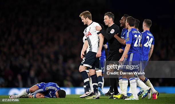 Tottenham Hotspur's Eric Dier is pulled away by referee Mark Clattenburg after fouling Chelsea's Eden Hazard