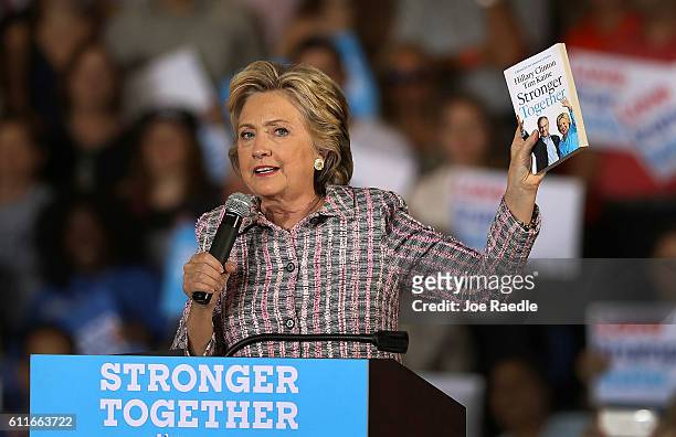 Democratic presidential candidate Hillary Clinton holds up a book as she speaks during a campaign rally at the Sunrise Theatre on September 30, 2016...