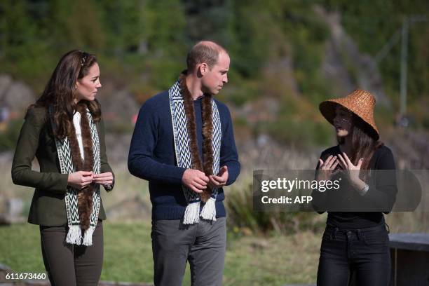 The Duke and Duchess of Cambridge, learn about totem poles from a member of the Haida First Nation during a visit to the Haida Heritage Centre and...