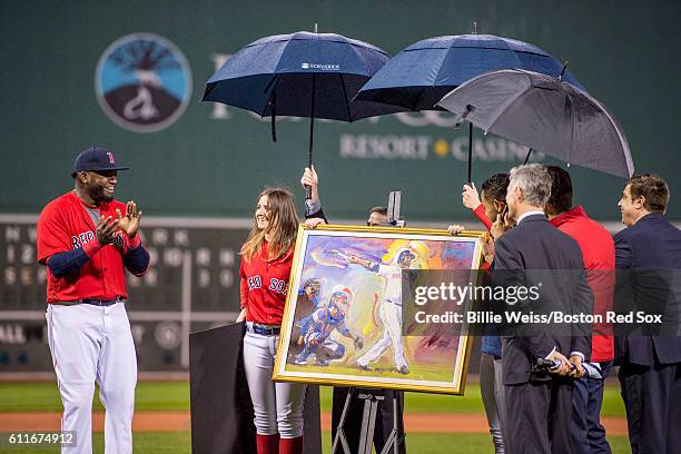 David Ortiz of the Boston Red Sox reacts as he is presented with a painting by artist Peter Max during a retirement tribute ceremony before a game...