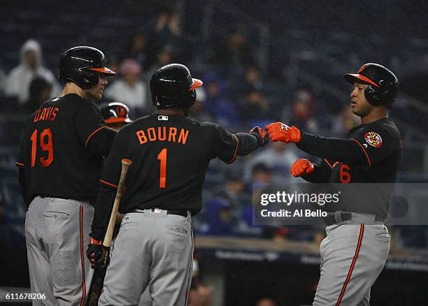 Jonathan Schoop of the Baltimore Orioles celebrates with Michael Bourn and Chris Davis after hitting a three run home run against the New York...