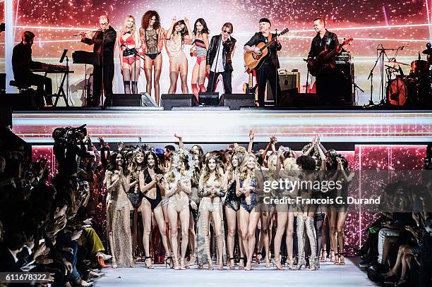 Models walk the runway while singer Jacques Dutronc performs on stage during the Etam show as part of the Paris Fashion Week Womenswear Spring/Summer...