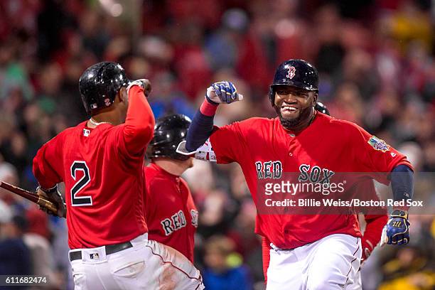 David Ortiz of the Boston Red Sox high fives Xander Bogaerts after hitting a go ahead two run home run during the seventh inning of a game against...