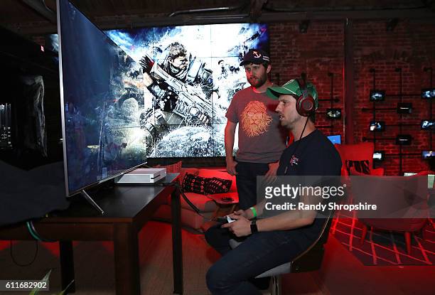 Actor Jon Heder, seated at right, and brother Dan attend the Xbox & Gears Of War 4 Los Angeles launch event at The Microsoft Lounge on September 30,...