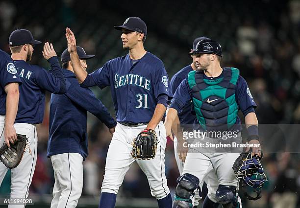 Relief pitcher Steve Cishek of the Seattle Mariners and catcher Mike Zunino, right, of the Seattle Mariners celebrate a win over the Oakland...