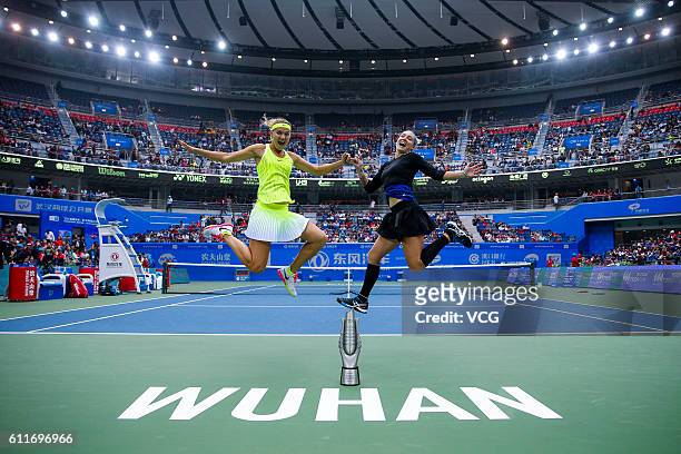 Bethanie Mattek-Sands of the United States and Lucie Safarova of the Czech Republic jump for pictures after winning the women's doubles final match...