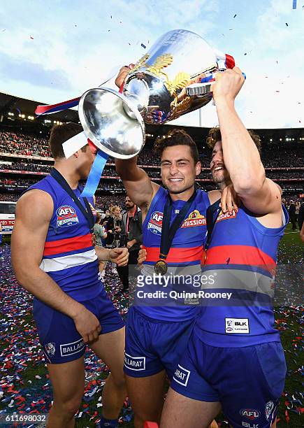 Josh Dunkley, Luke Dahlhaus and Tom Liberatore of the Bulldogs celebrates with the trophy after winning the 2016 AFL Grand Final match between the...