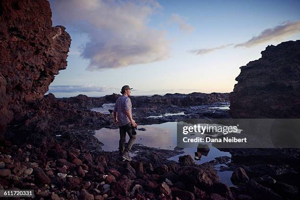 man walking with camera on lava rocks - lanai stock pictures, royalty-free photos & images