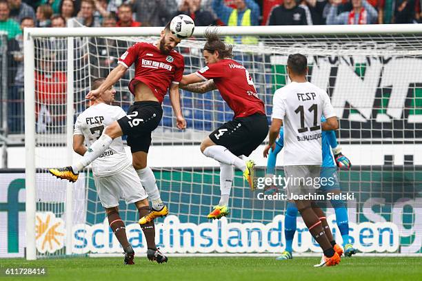 Kenan Karaman and Stefan Strandberg of Hannover challenges Bernd Nehrig and Aziz Bouhaddouz of St. Pauli during the Second Bundesliga match between...