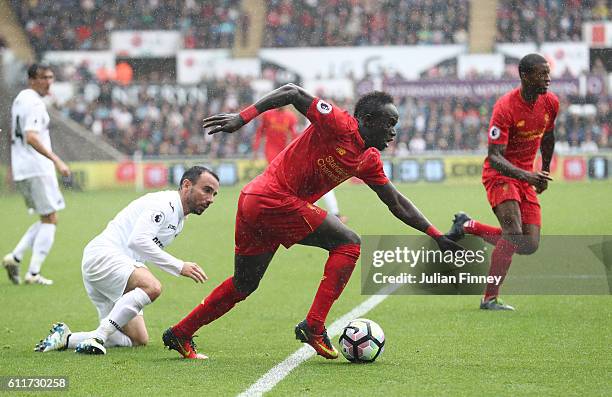 Sadio Mane of Liverpool takes the ball past Leon Britton of Swansea City during the Premier League match between Swansea City and Liverpool at...