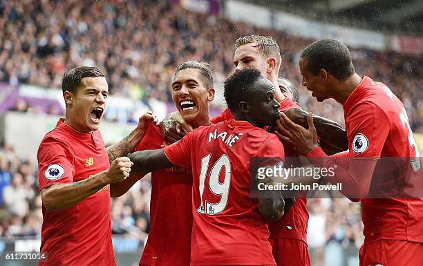 Roberto Firmino of Liverpool Scores and celebrates with his teamates after putting liverpool level at 1-1 during the Premier League match between...